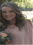 A woman in a pink top is smiling and holding a bouquet of flowers