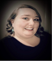 A woman wearing a black shirt and earrings smiles for the camera