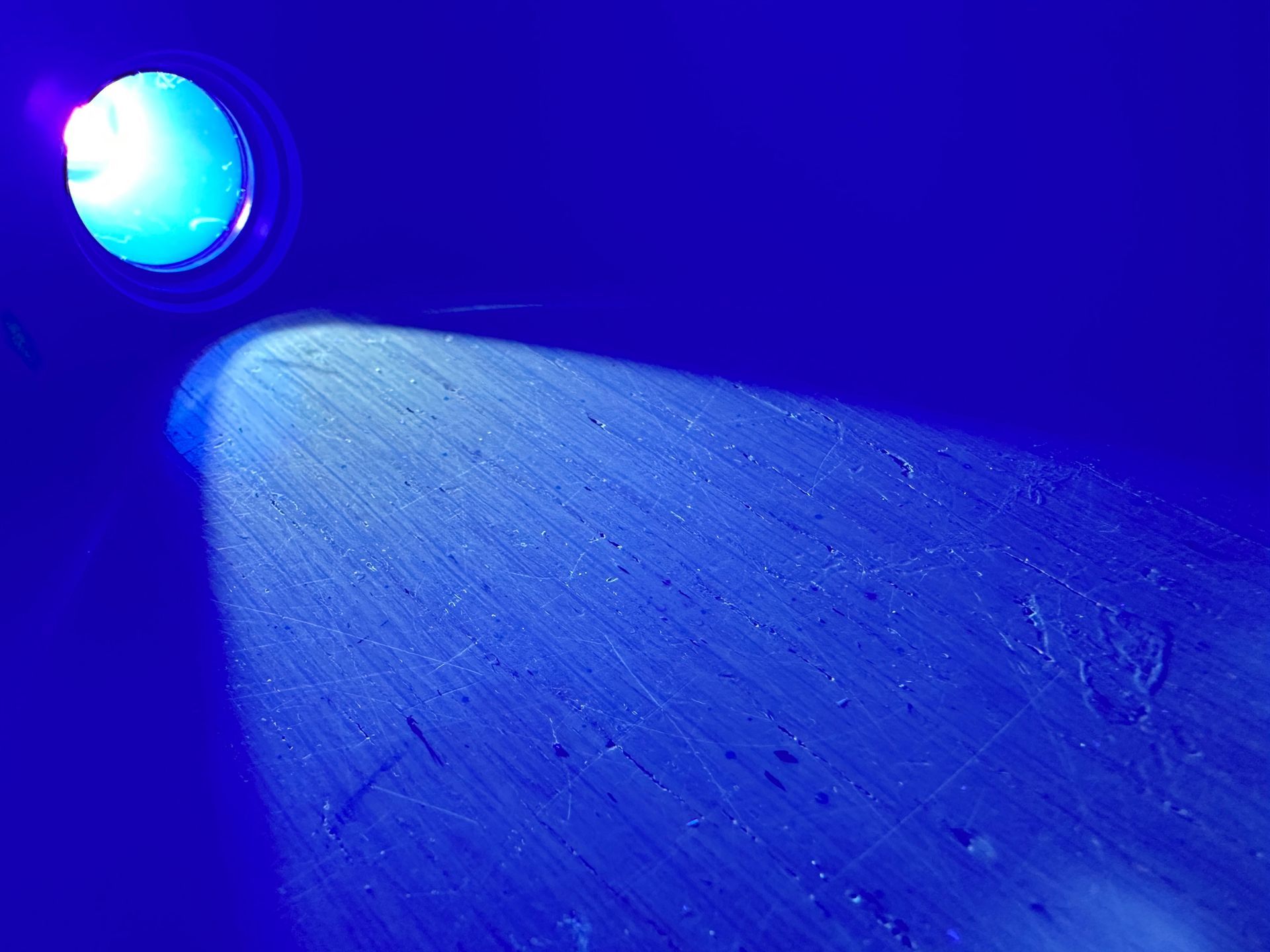 A person is cleaning a pillow with a uv light