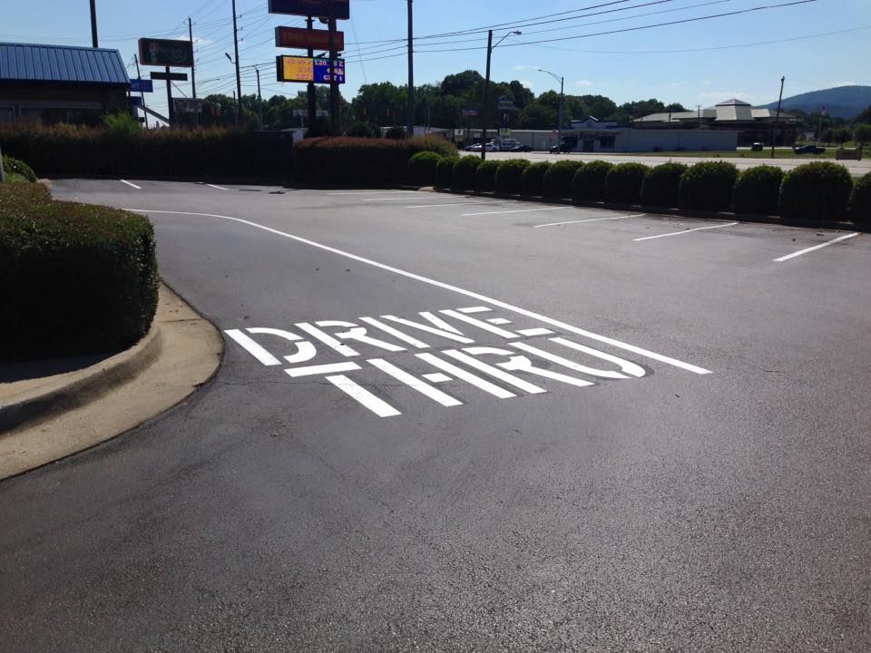 An asphalt parking lot showing a white, painted