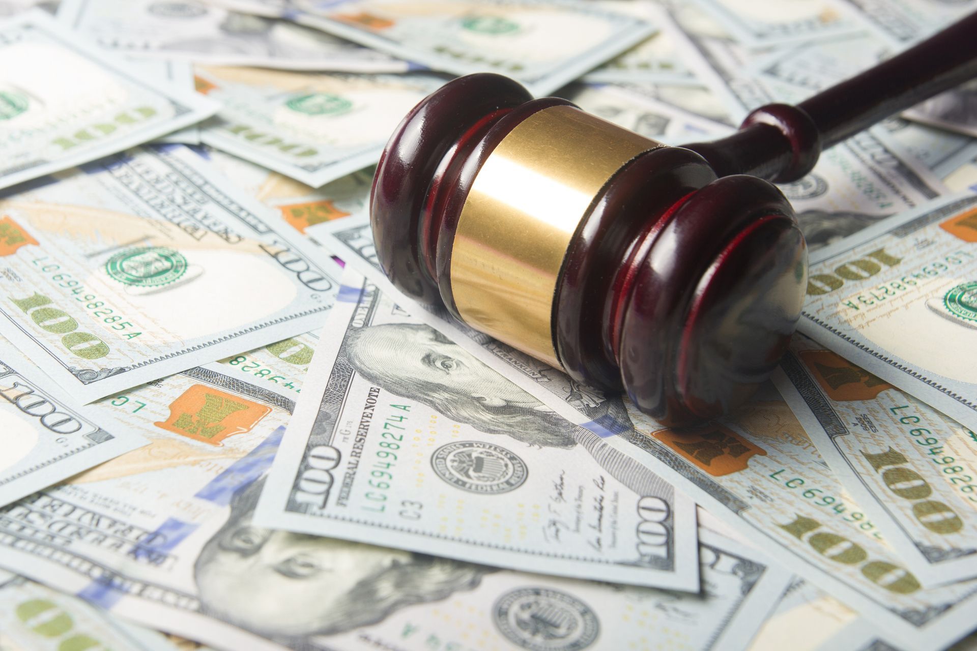 A judge 's gavel is sitting on top of a pile of money.