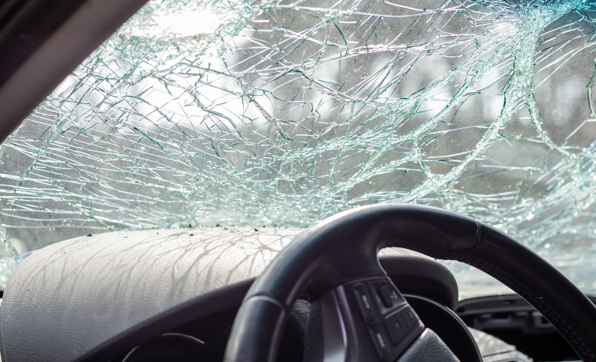 A car with a broken windshield and steering wheel