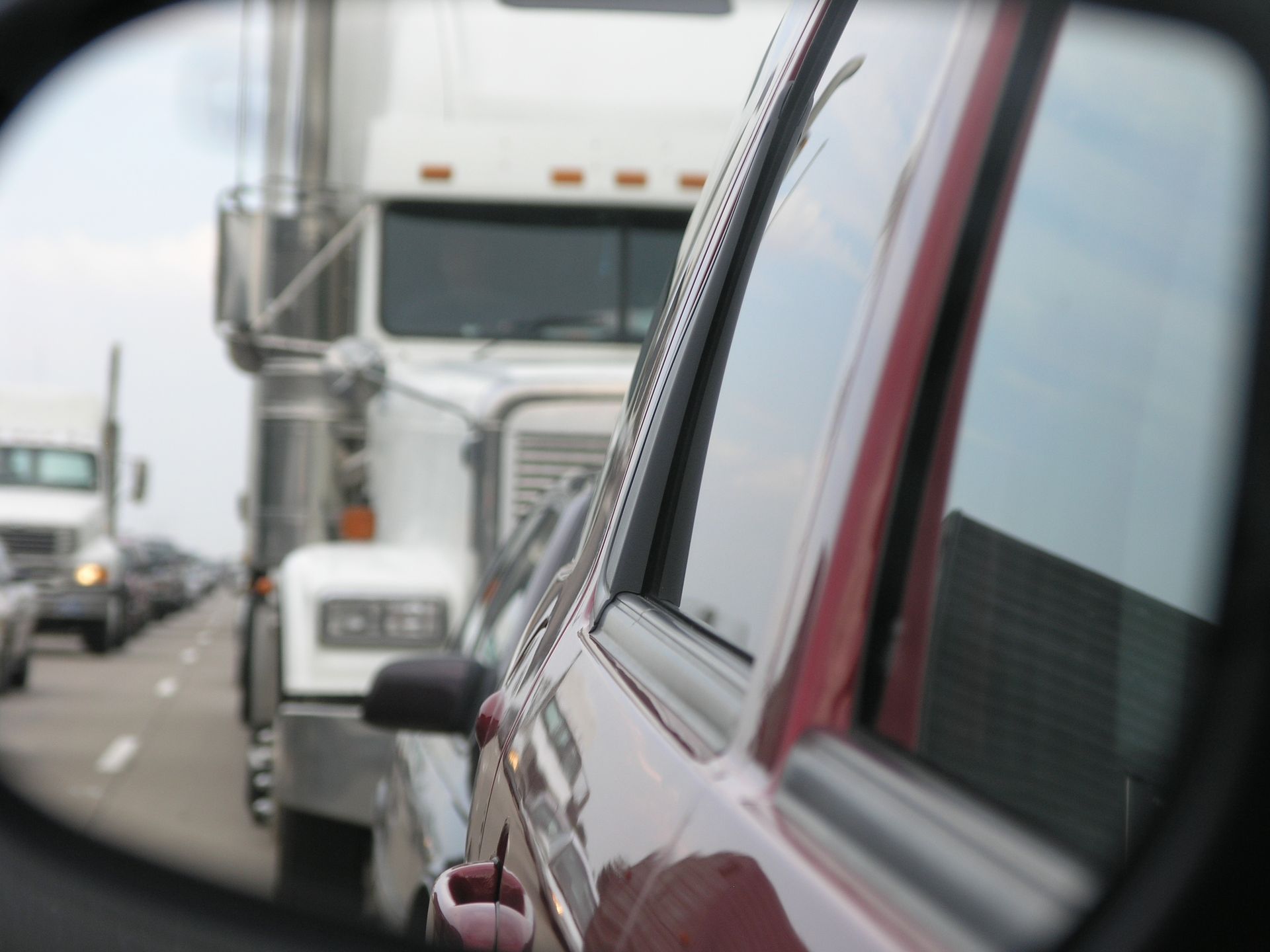 A truck is reflected in a rear view mirror