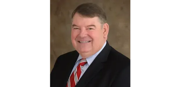 A man in a suit and tie is smiling for the camera.