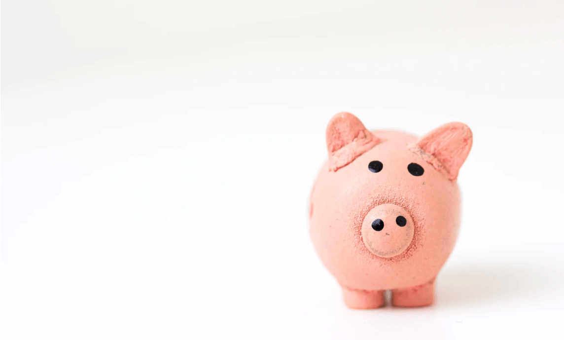 Pink piggy bank on a while background