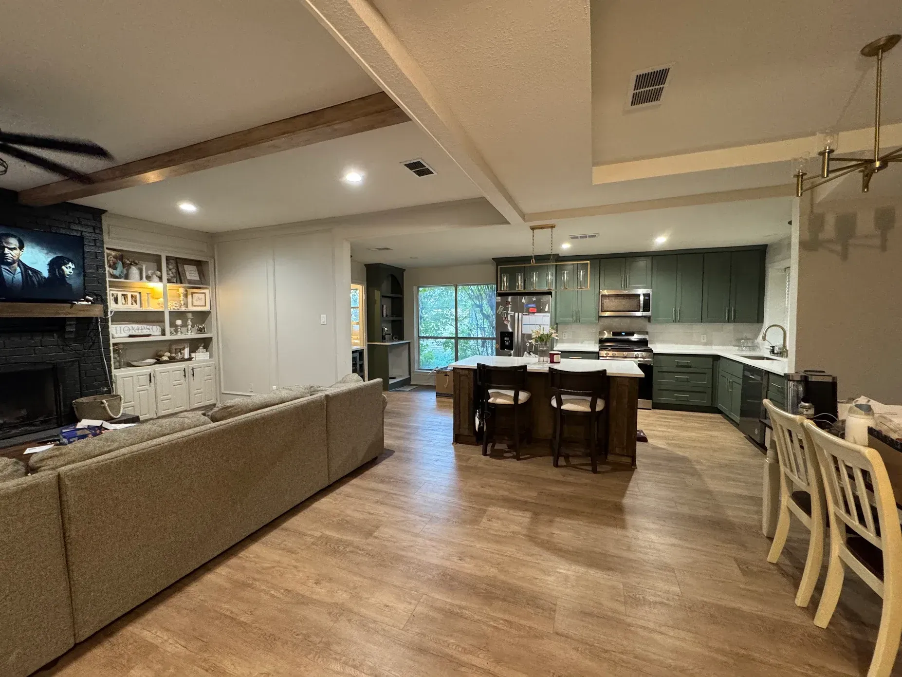 White kitchen with granite countertops, stainless steel appliances, and a sink in the foreground.