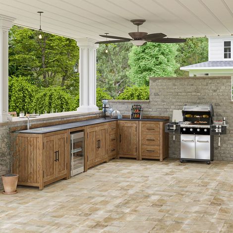 Outdoor covered patio with wood cabinets, stone countertops, ceiling fans, and a stainless steel grill