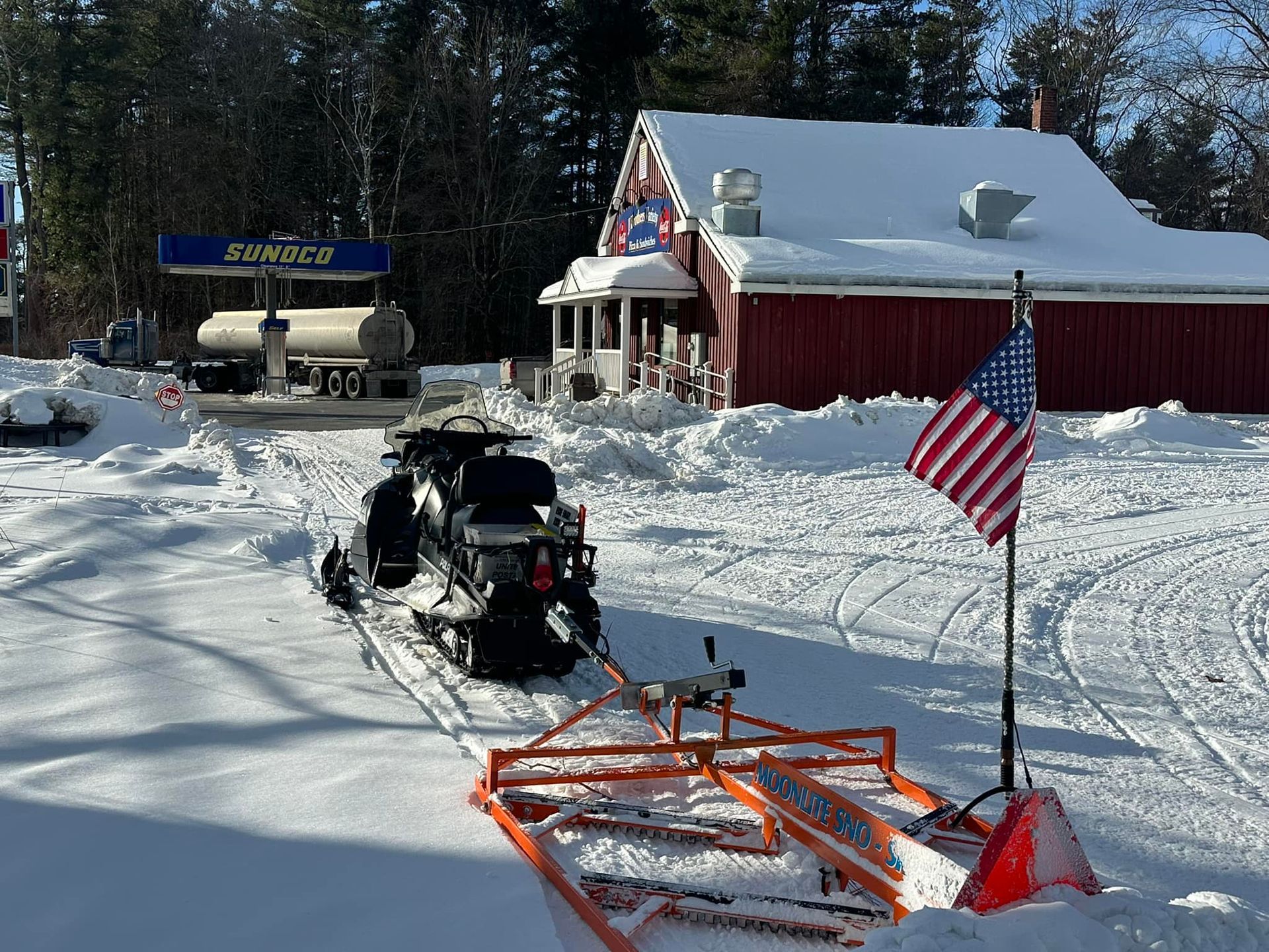 A snowmobile is parked in front of a gas station