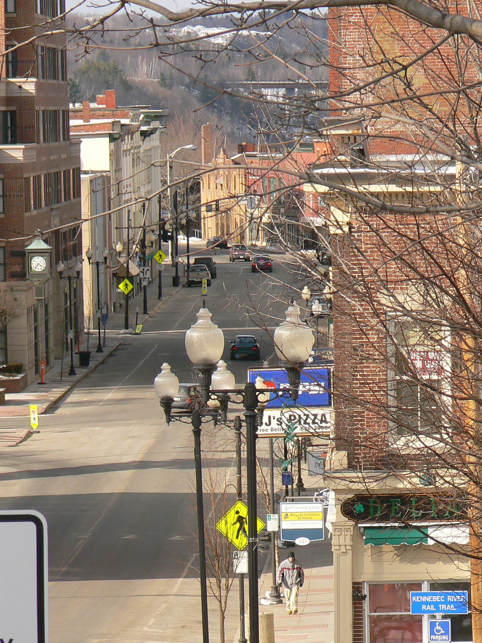 An aerial view of a city street with a yellow and black crosswalk sign