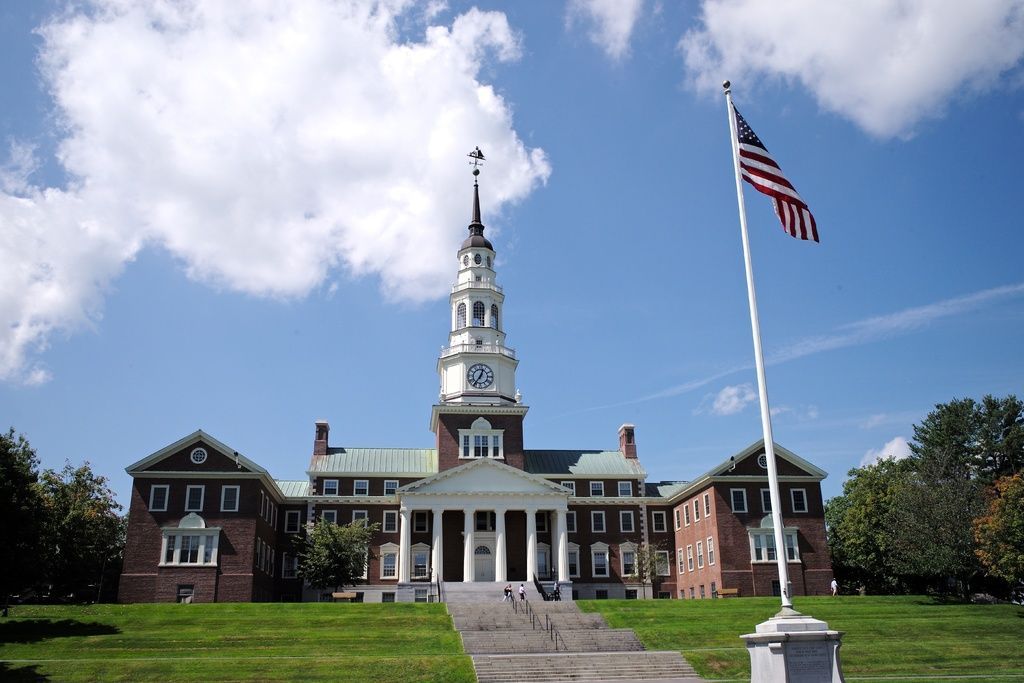 An american flag is flying in front of a large building
