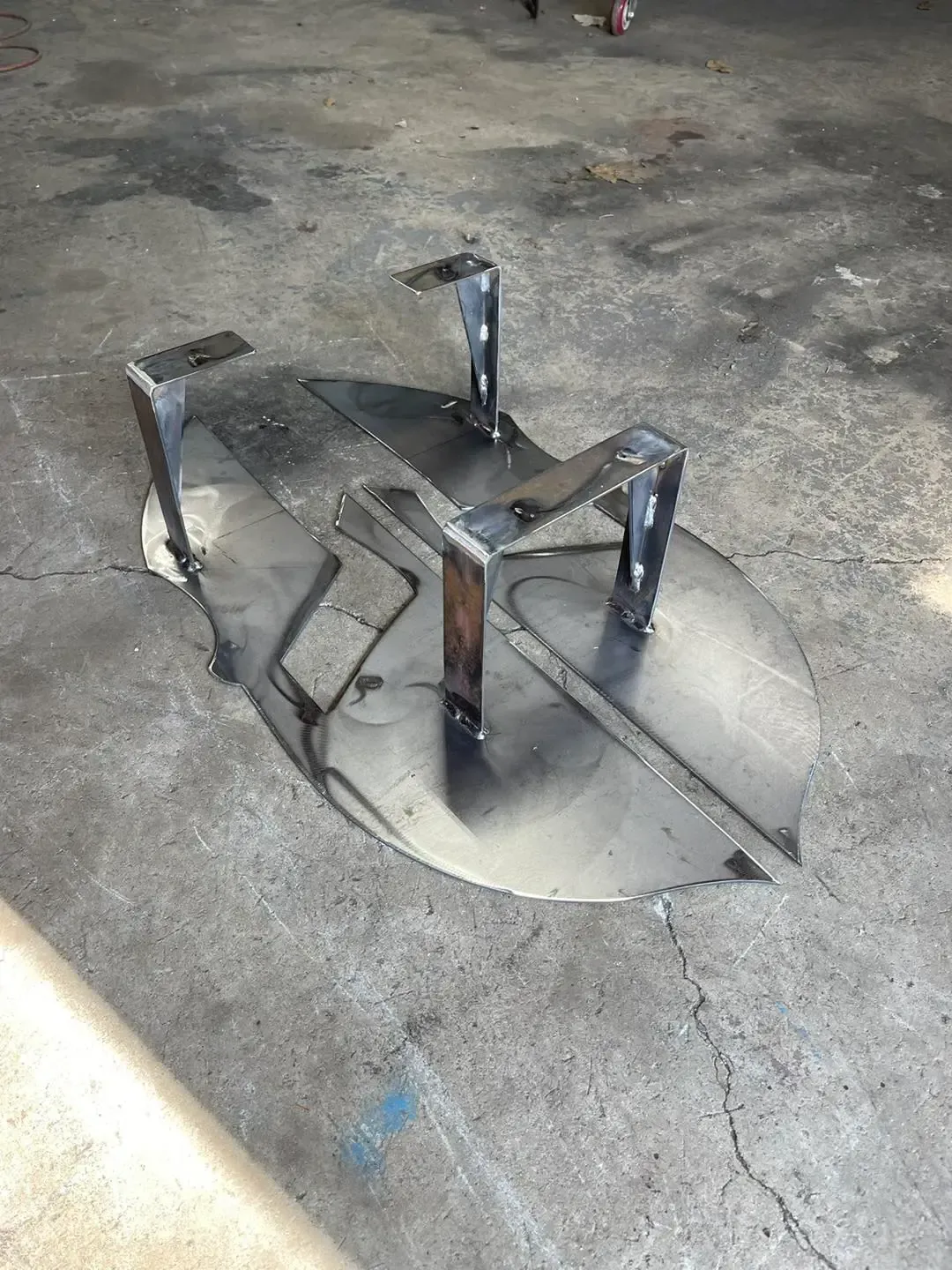 A piece of metal is sitting on top of a concrete floor.