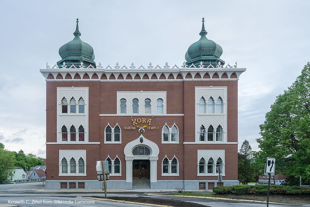 A large brick building with two green domes on top of it