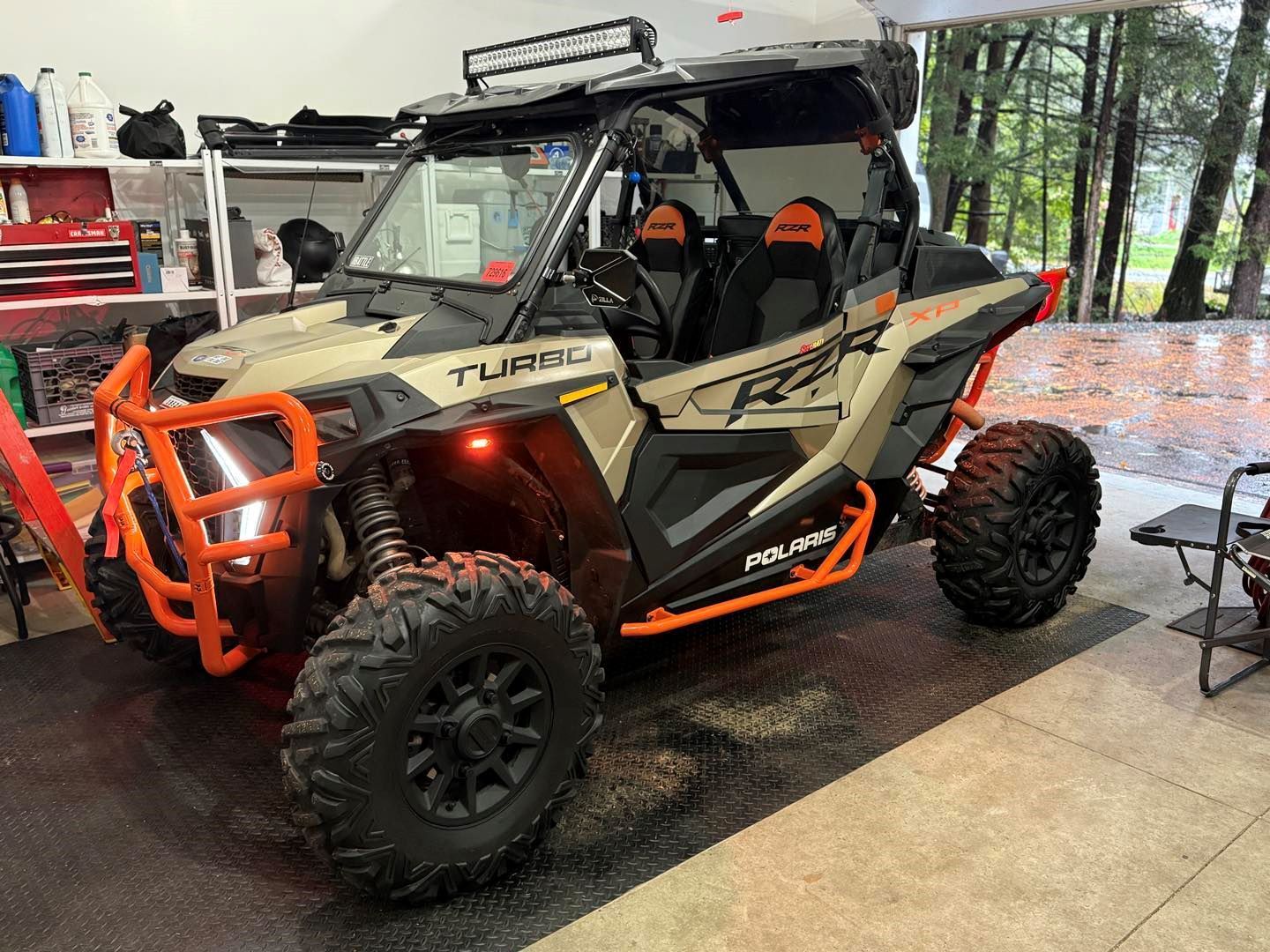 A polaris rzr 1000 turbo is parked in a garage.