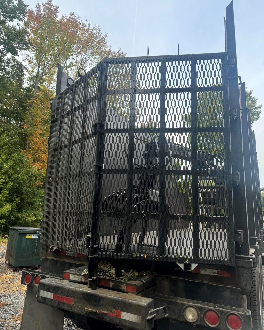 The back of a truck with a cage on it.