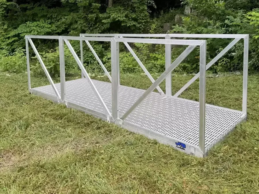 A metal bridge is sitting on top of a lush green field.