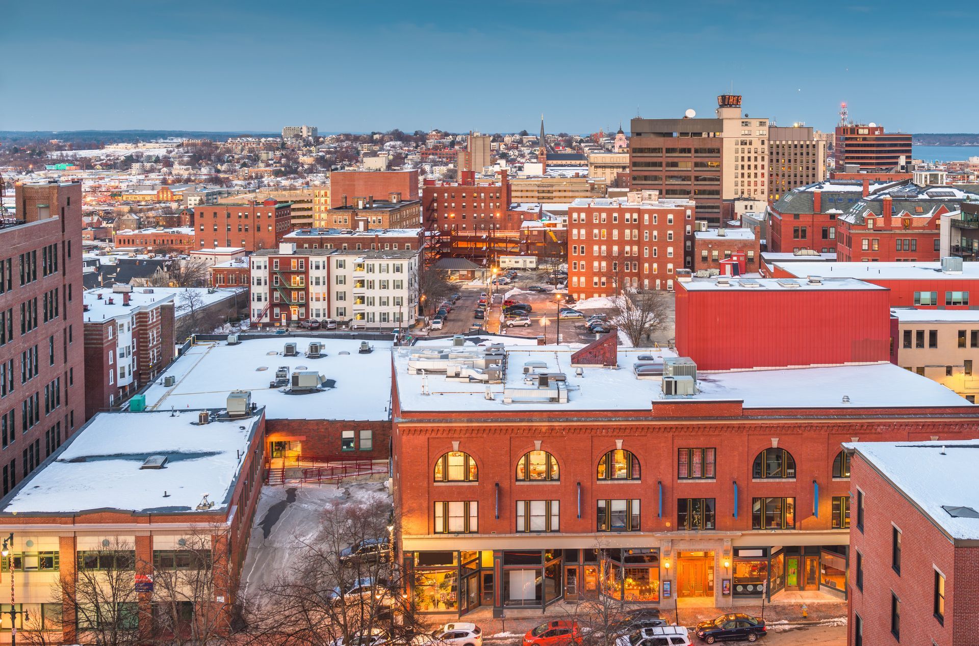 An aerial view of a city with snow on the roofs of buildings