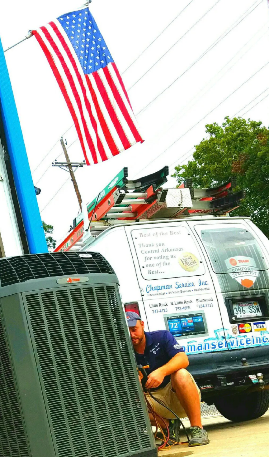 American flag above a sidewalk scene with a green utility box and a parked work van.