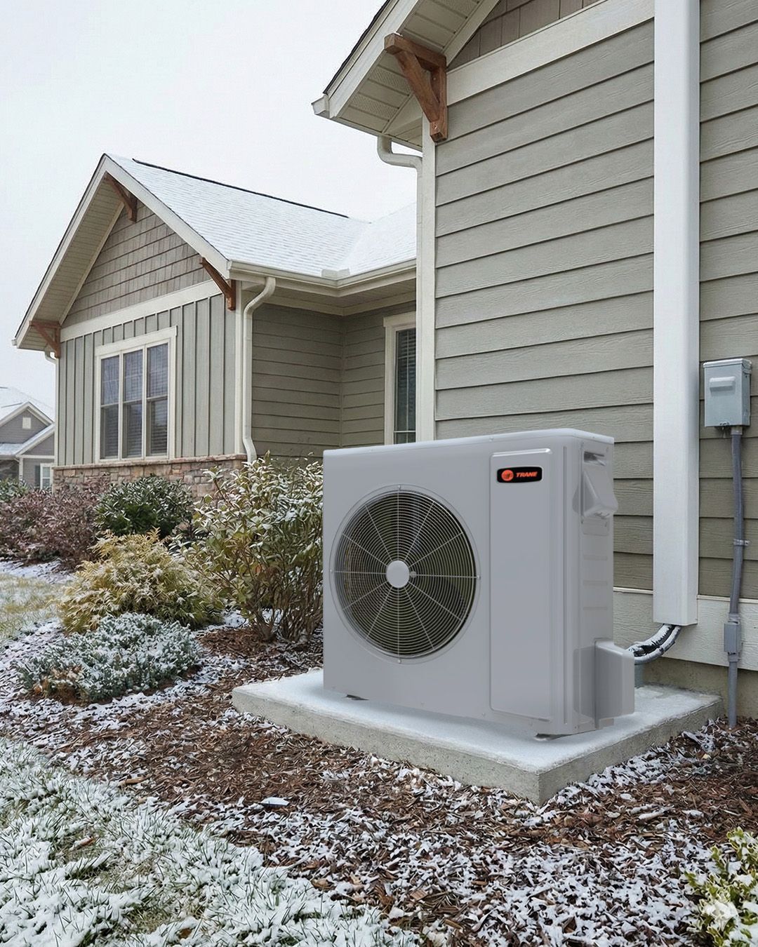 Snowy yard beside a house with a white outdoor HVAC unit on a concrete pad