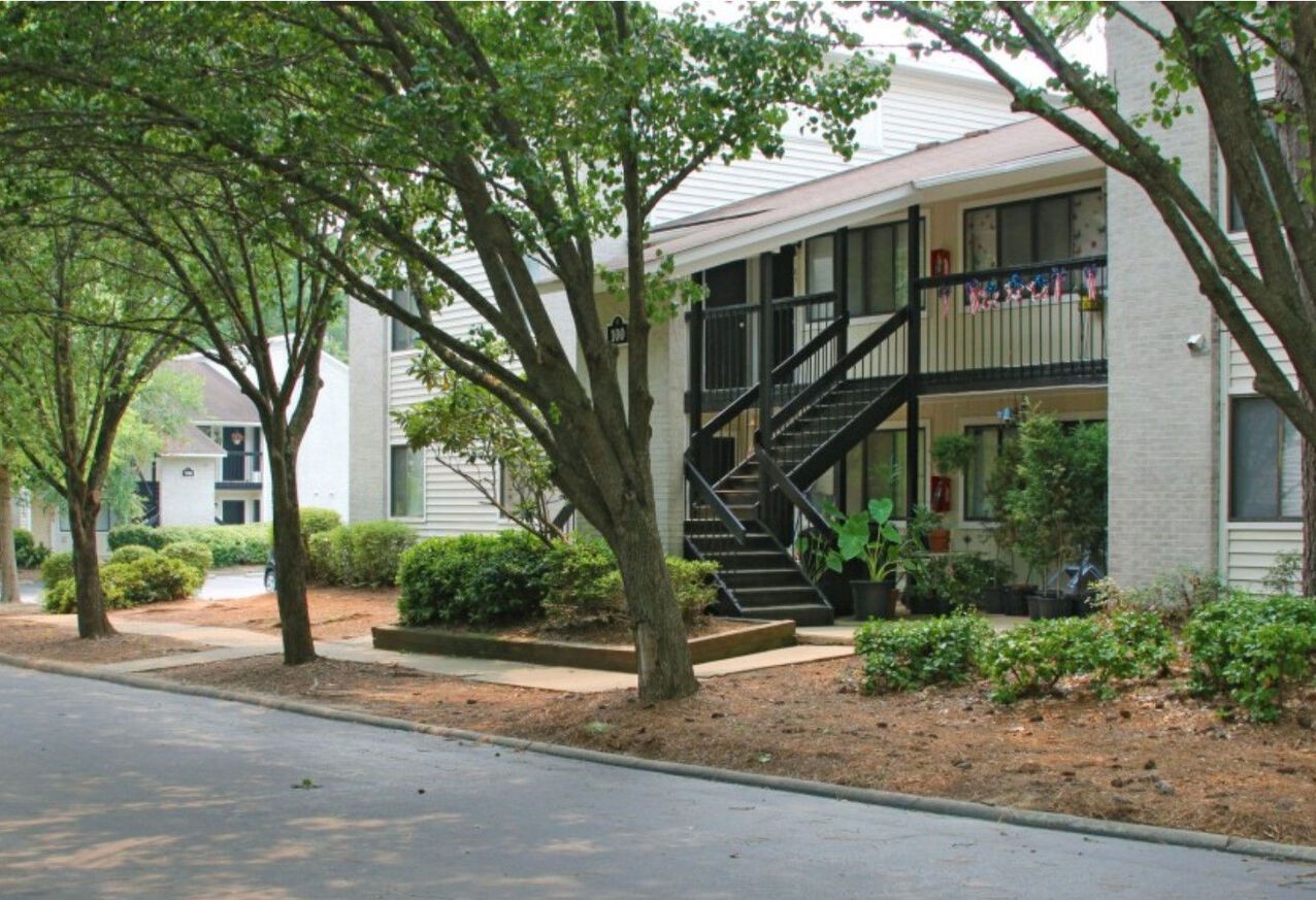 A white apartment building with stairs leading up to the second floor