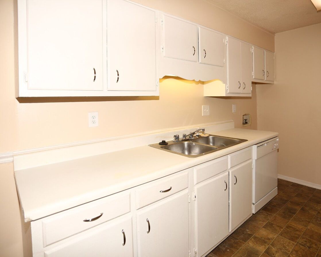A kitchen with white cabinets and a sink
