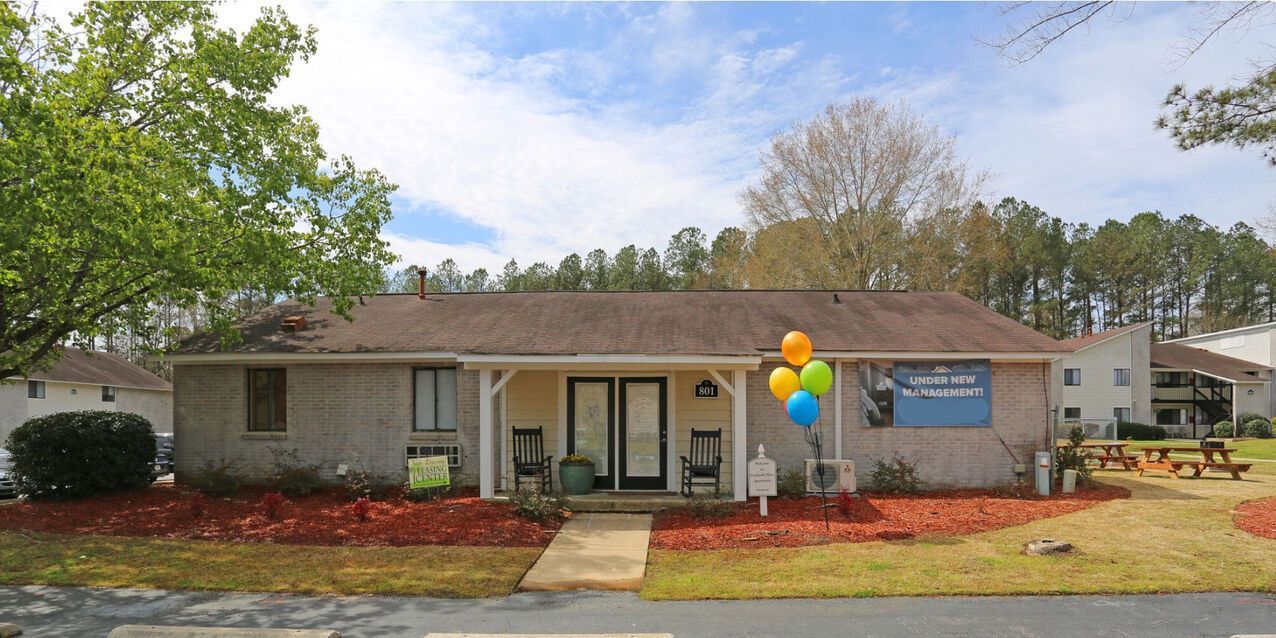 A house with a porch and balloons in front of it.