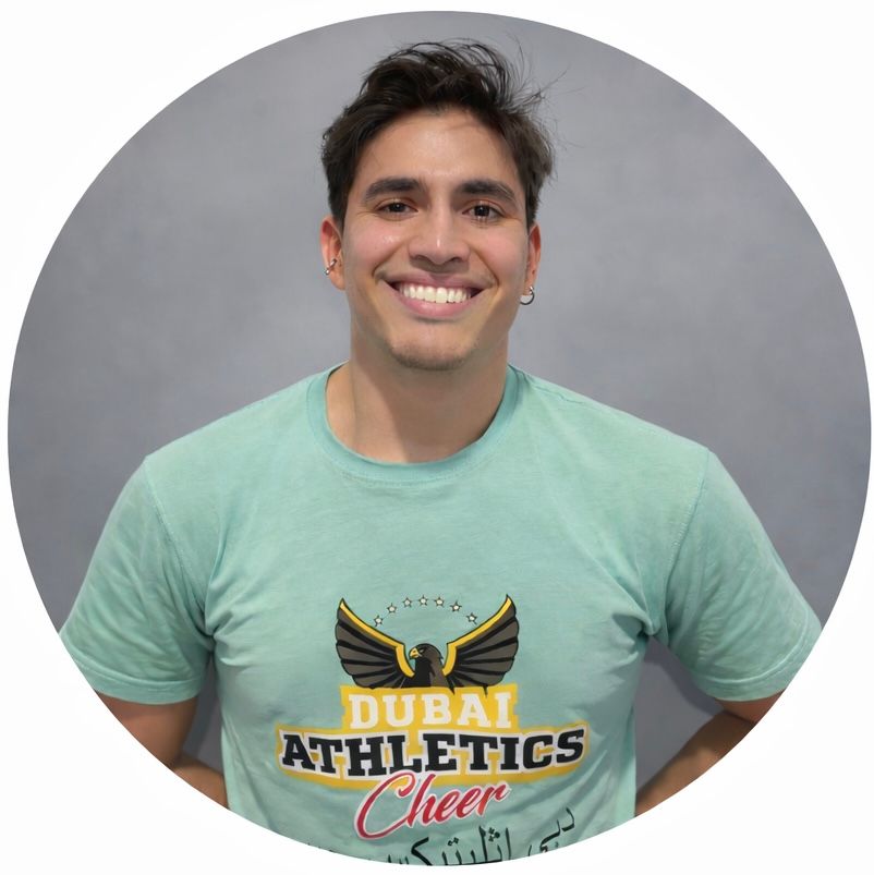 Man smiling, wearing a turquoise shirt with 