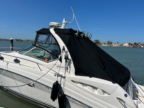 Boat cabin with clear vinyl windows against a blue sky.