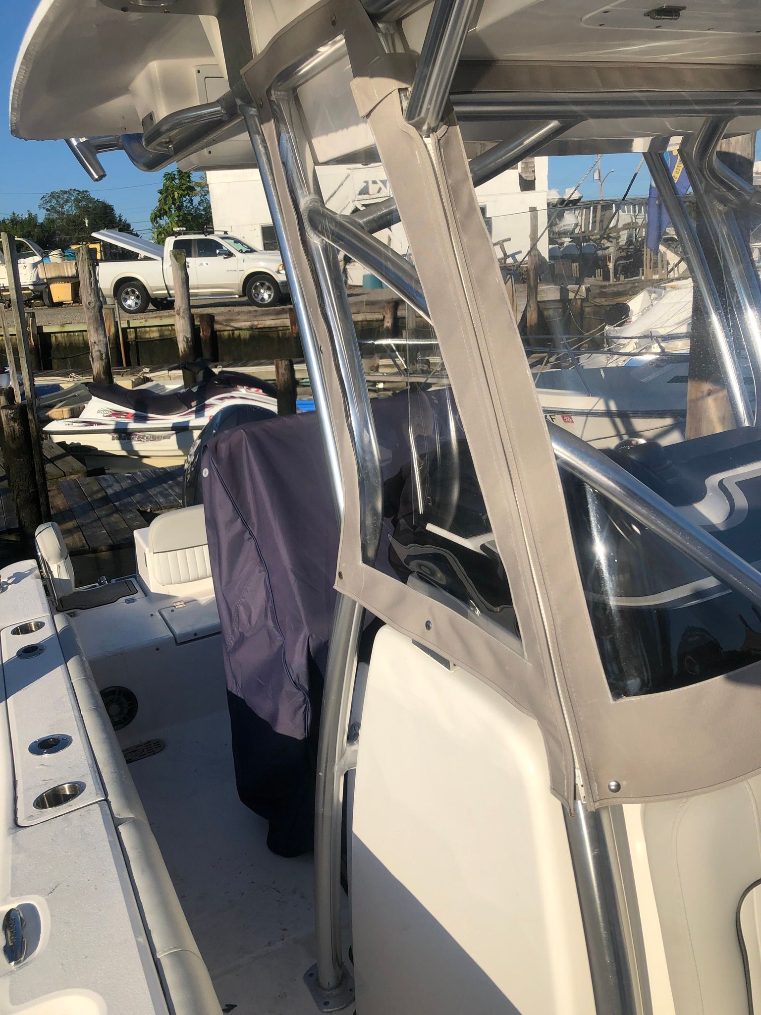 Boat cockpit with gray canvas, stainless steel frame, and white boat deck.