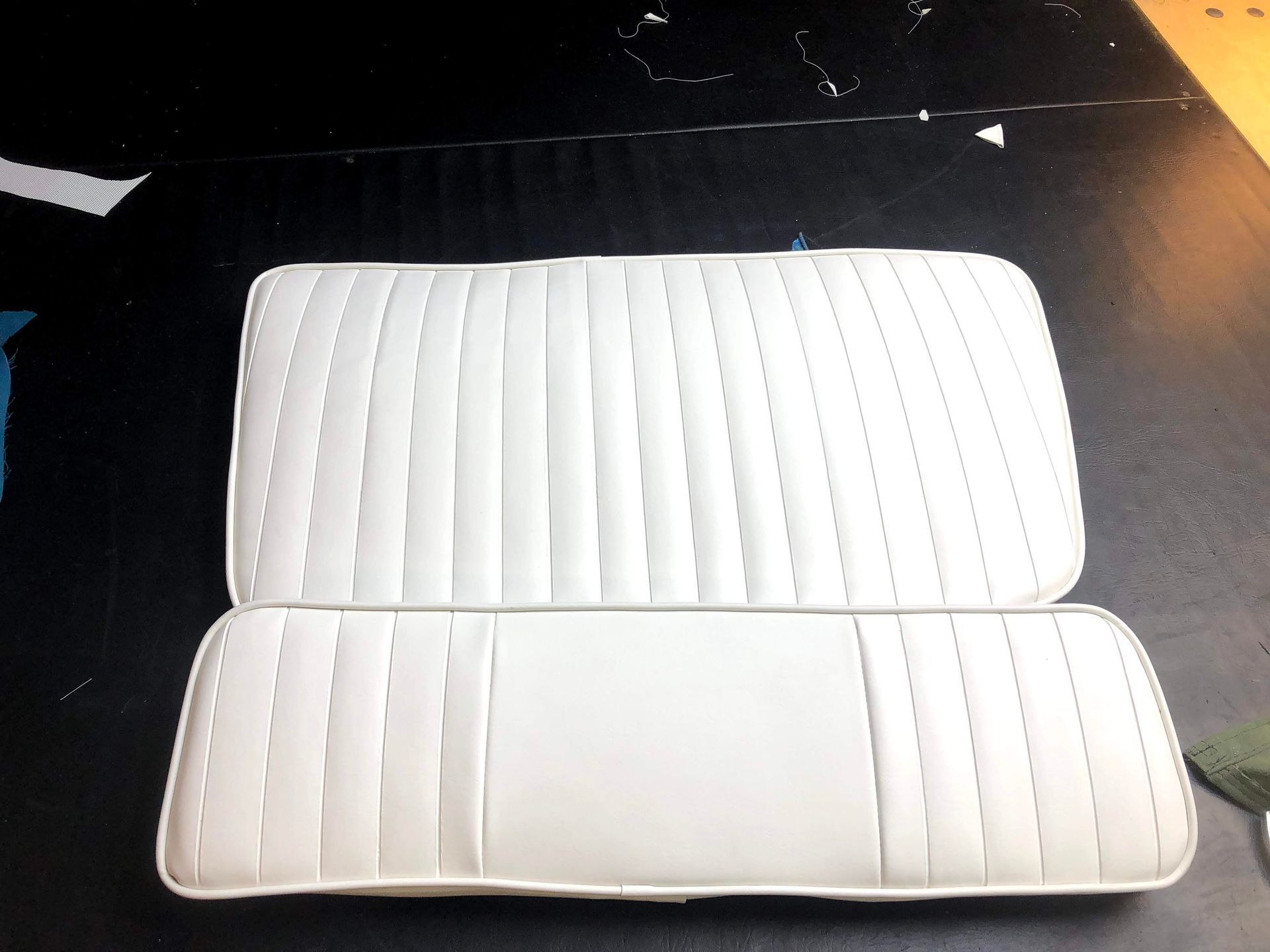 White boat seat cushions on a black surface.