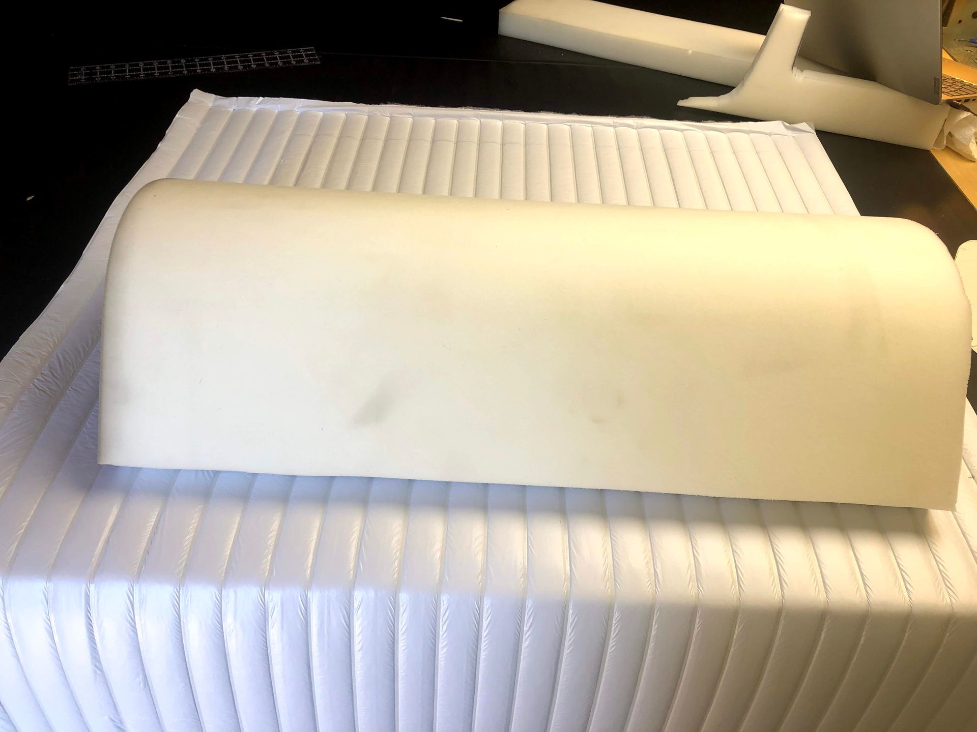 White foam cushion on quilted white fabric.