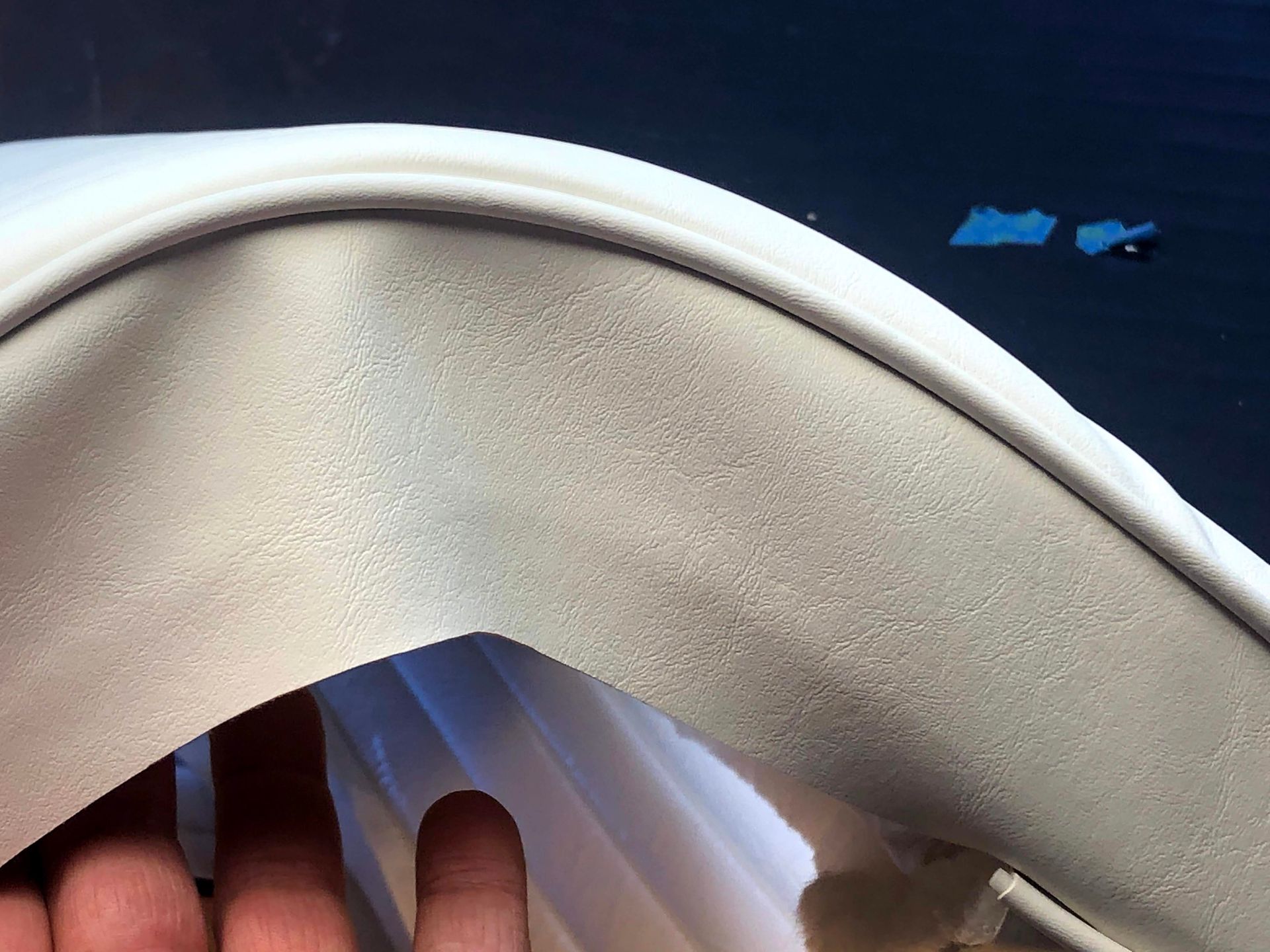 Close-up of a hand touching the inside of a white curved fabric edge.