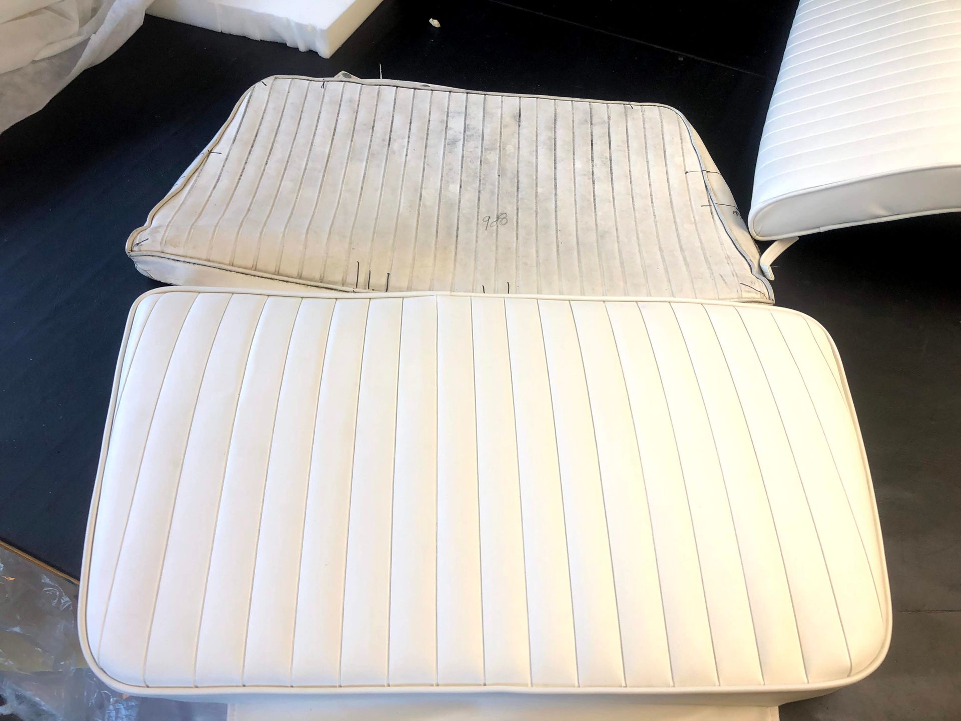 Two white boat seat cushions; one dirty, the other clean.