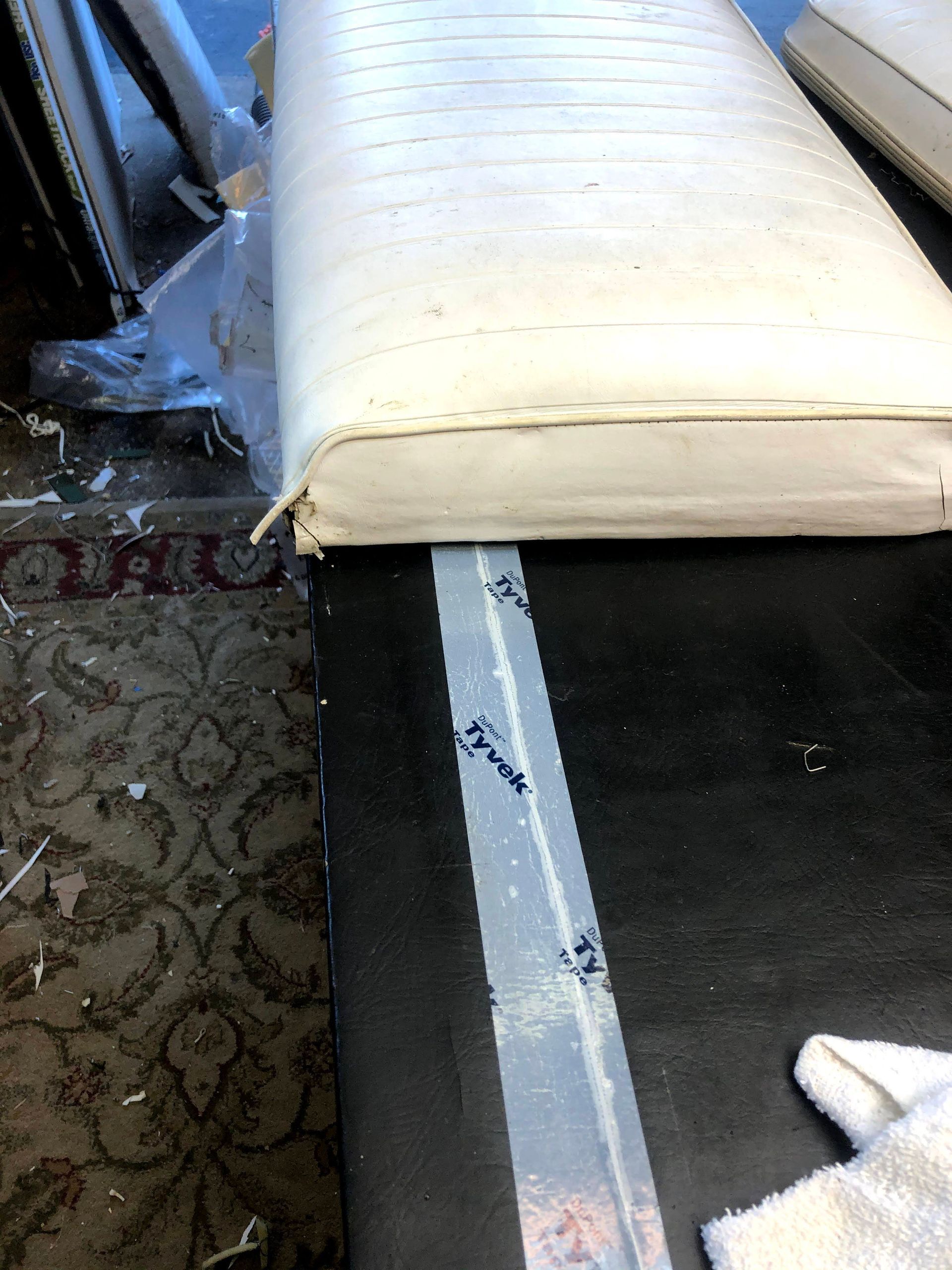 White seat cushion on black surface with Tyvek tape strip.