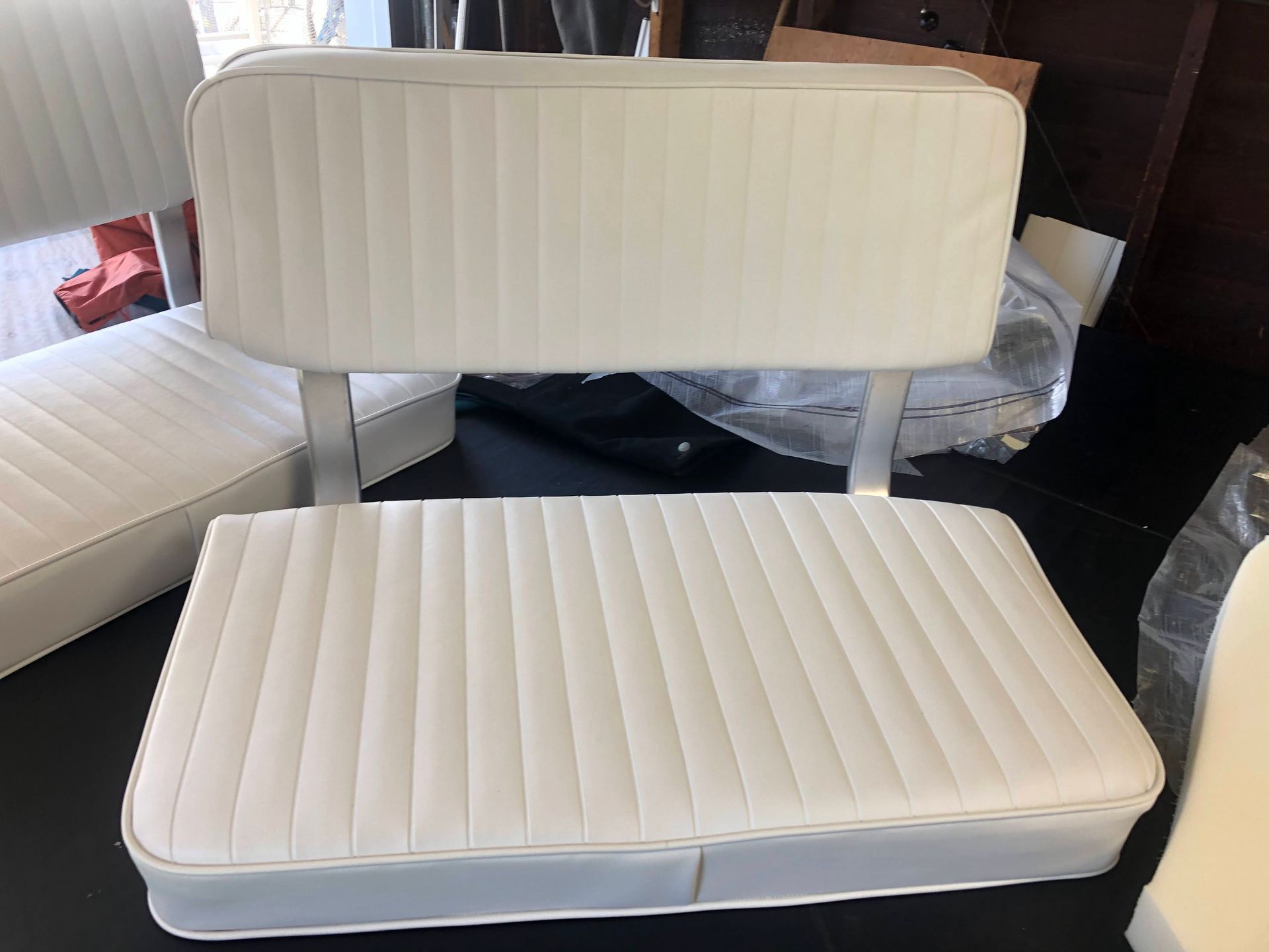 White boat seat with a back and vertical stitching.