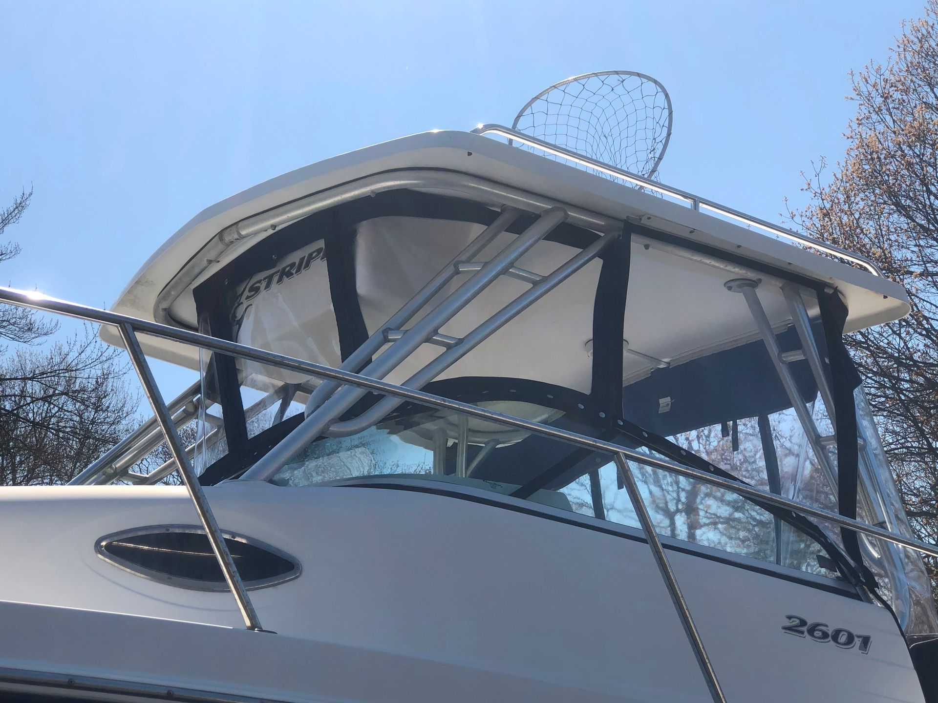 White boat cabin with black canvas and a fishing net.