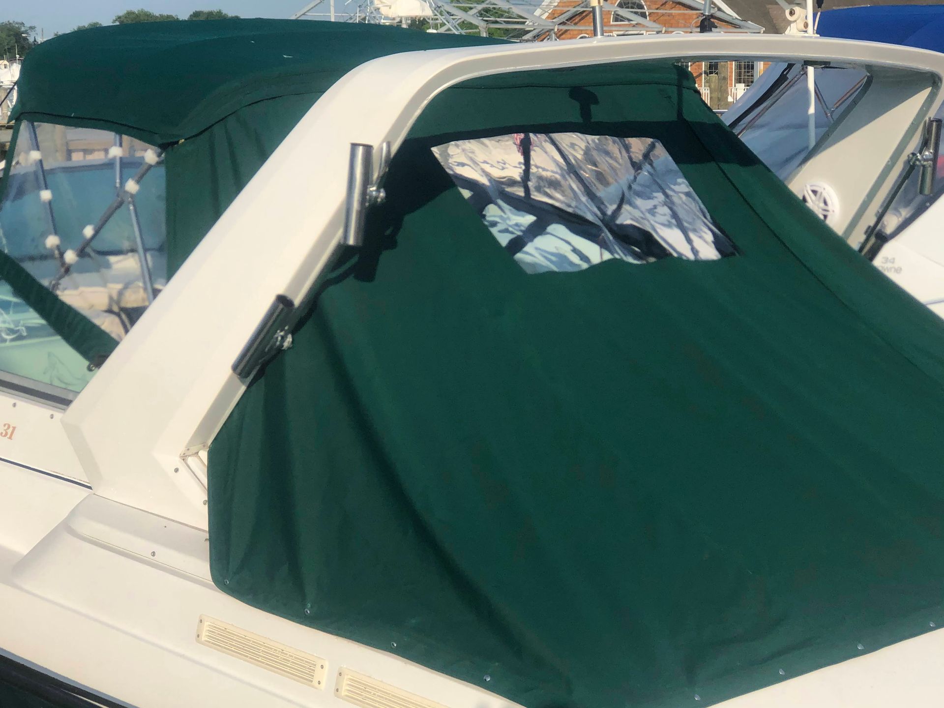 Green canvas boat cover on white frame.