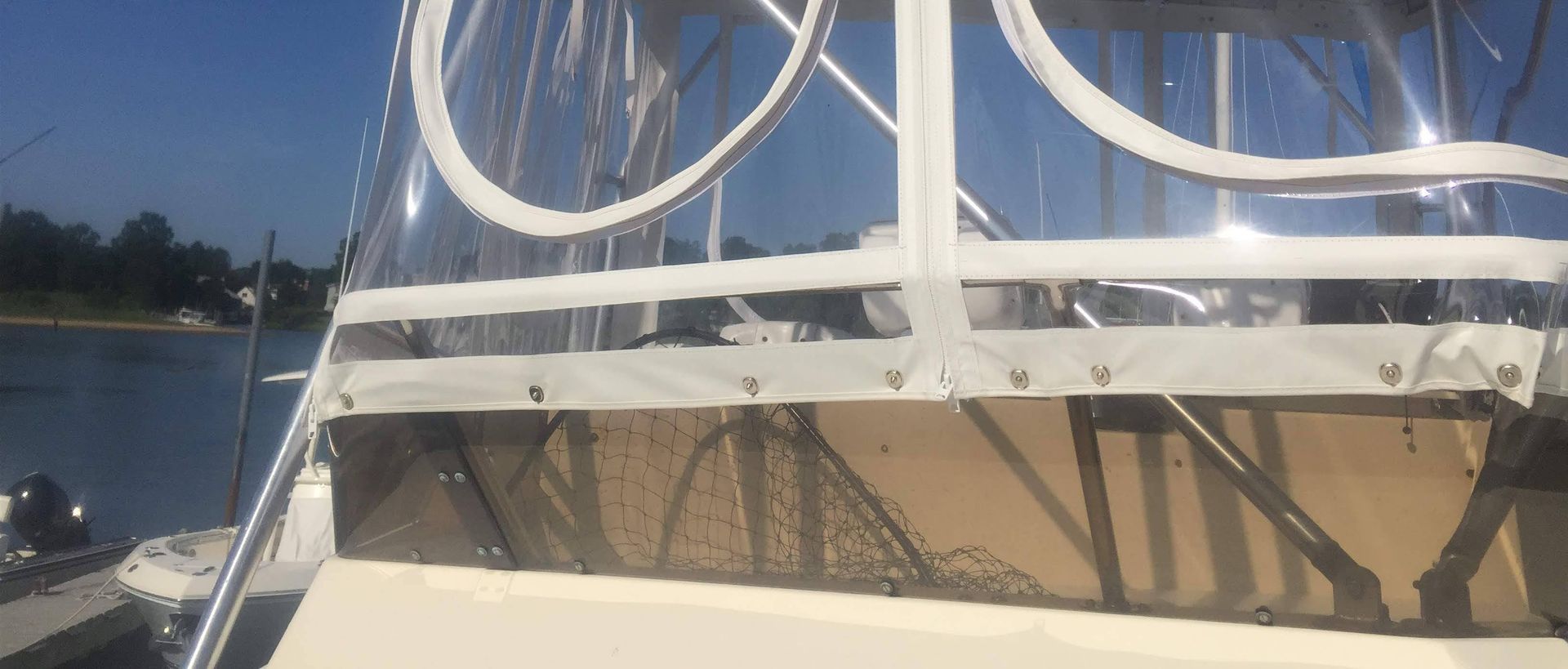 Boat with clear vinyl enclosure, sunny day on the water, view from inside the boat.
