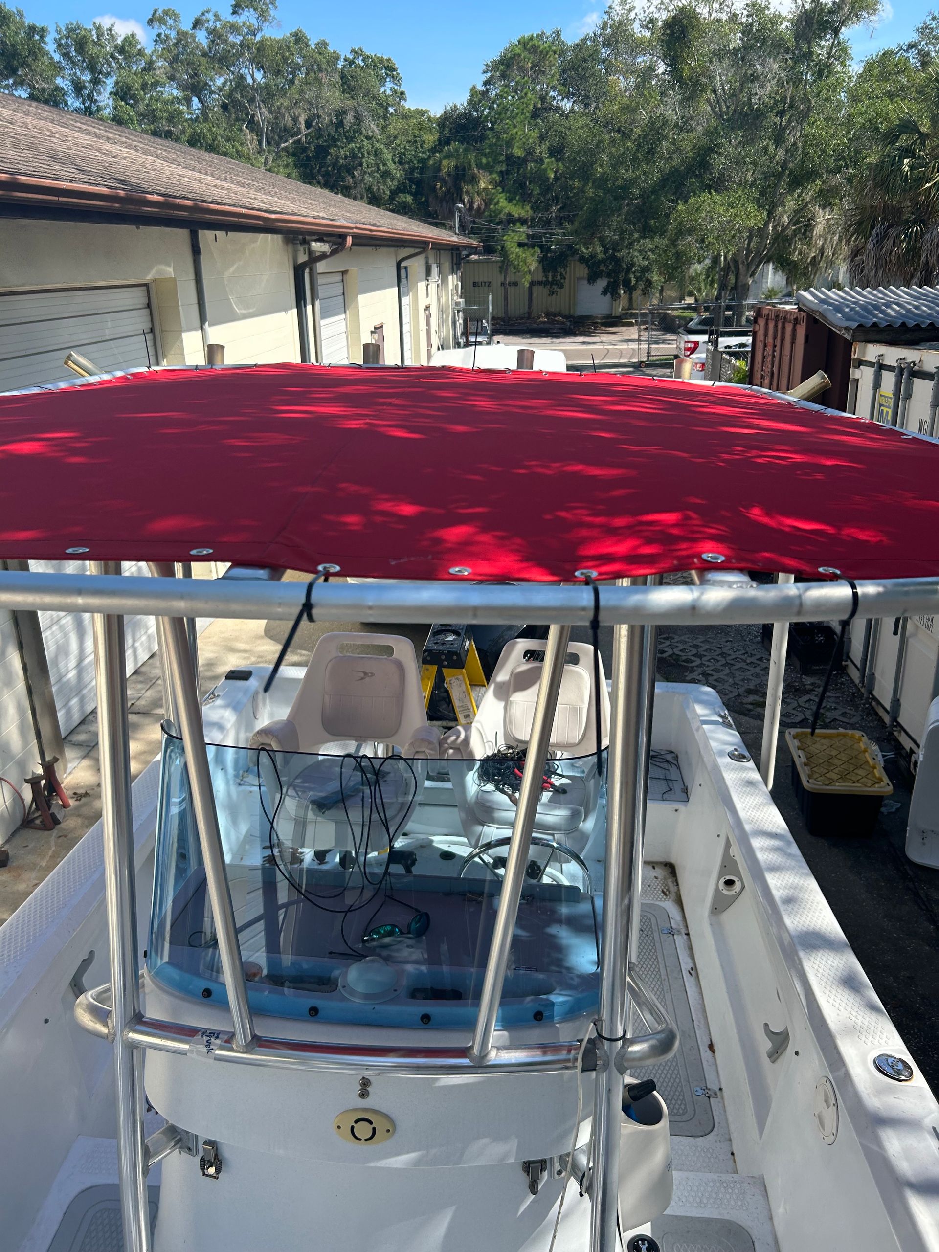 Boat cockpit with red canvas top; sunny outdoor setting.