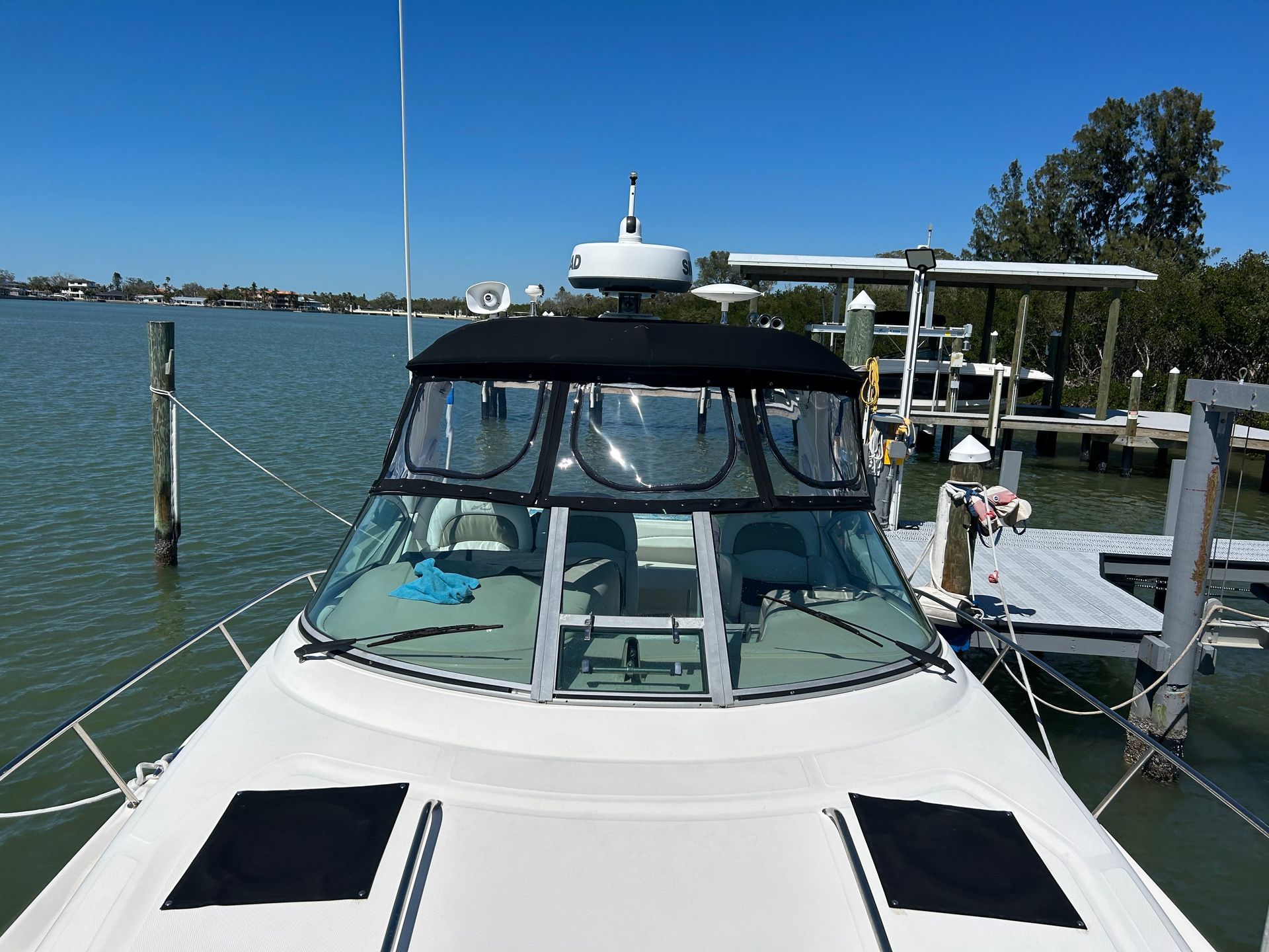 A motorboat docked at a pier on a sunny day.