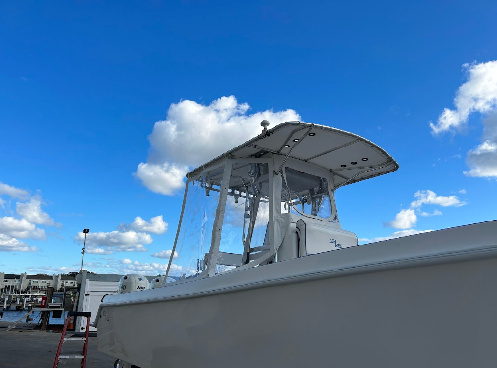 White boat with clear enclosure against a blue sky with clouds.