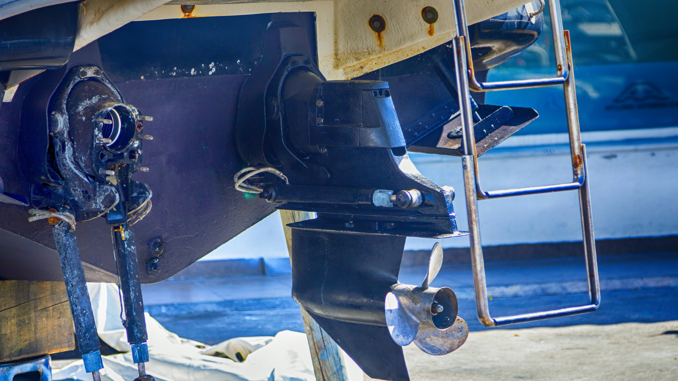 Boat's lower unit and propeller assembly, with a ladder attached, in a marine environment.