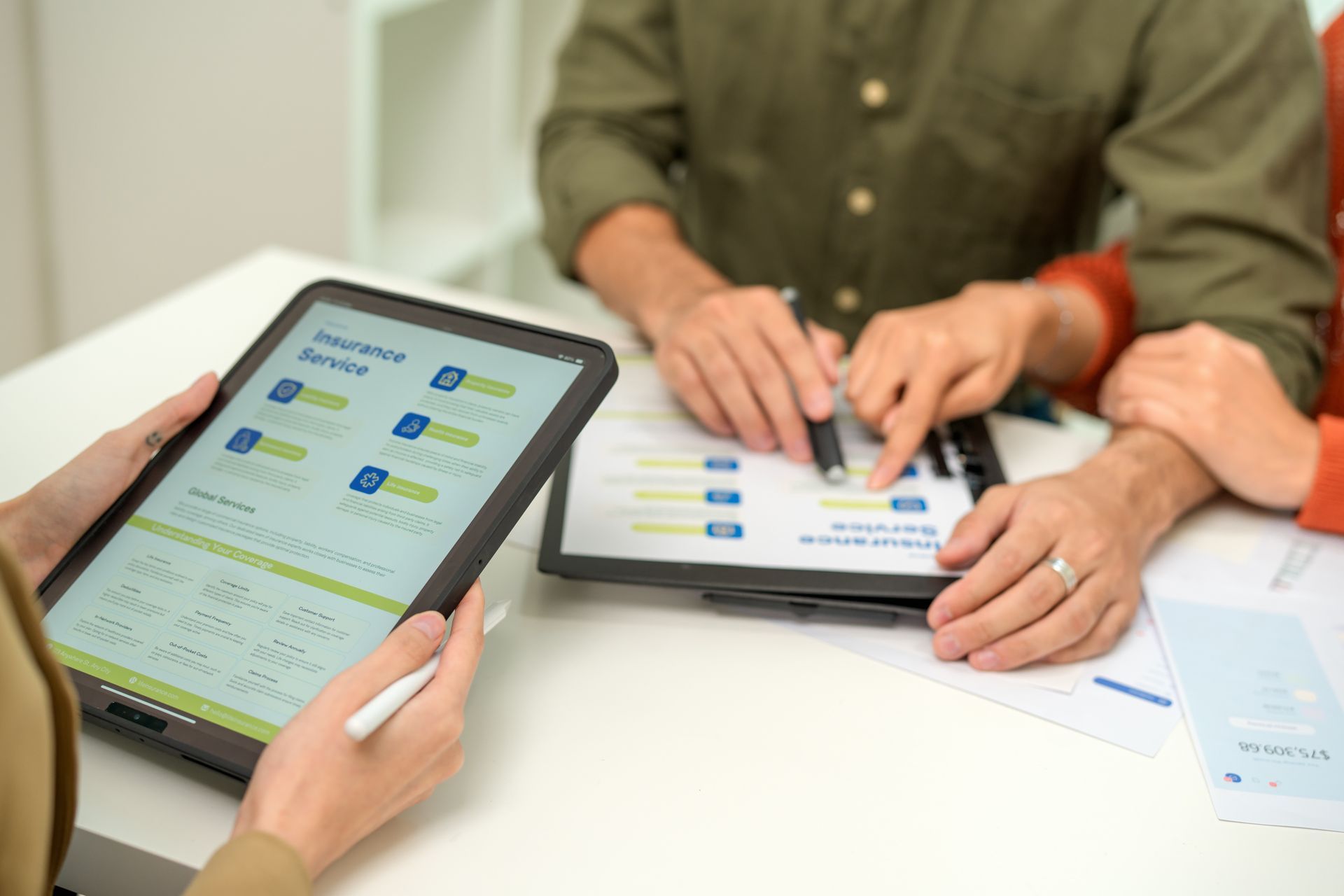 People using tablets at a white table, collaborating on a digital interface. People using tablets at a white table, collaborating on a digital interface.