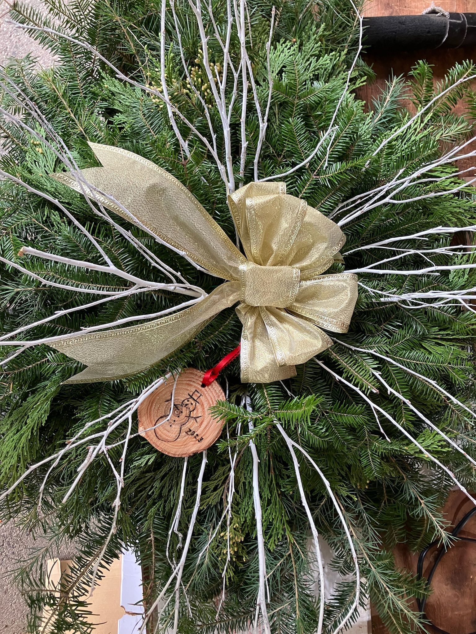 A christmas wreath with pine cones and a red bow