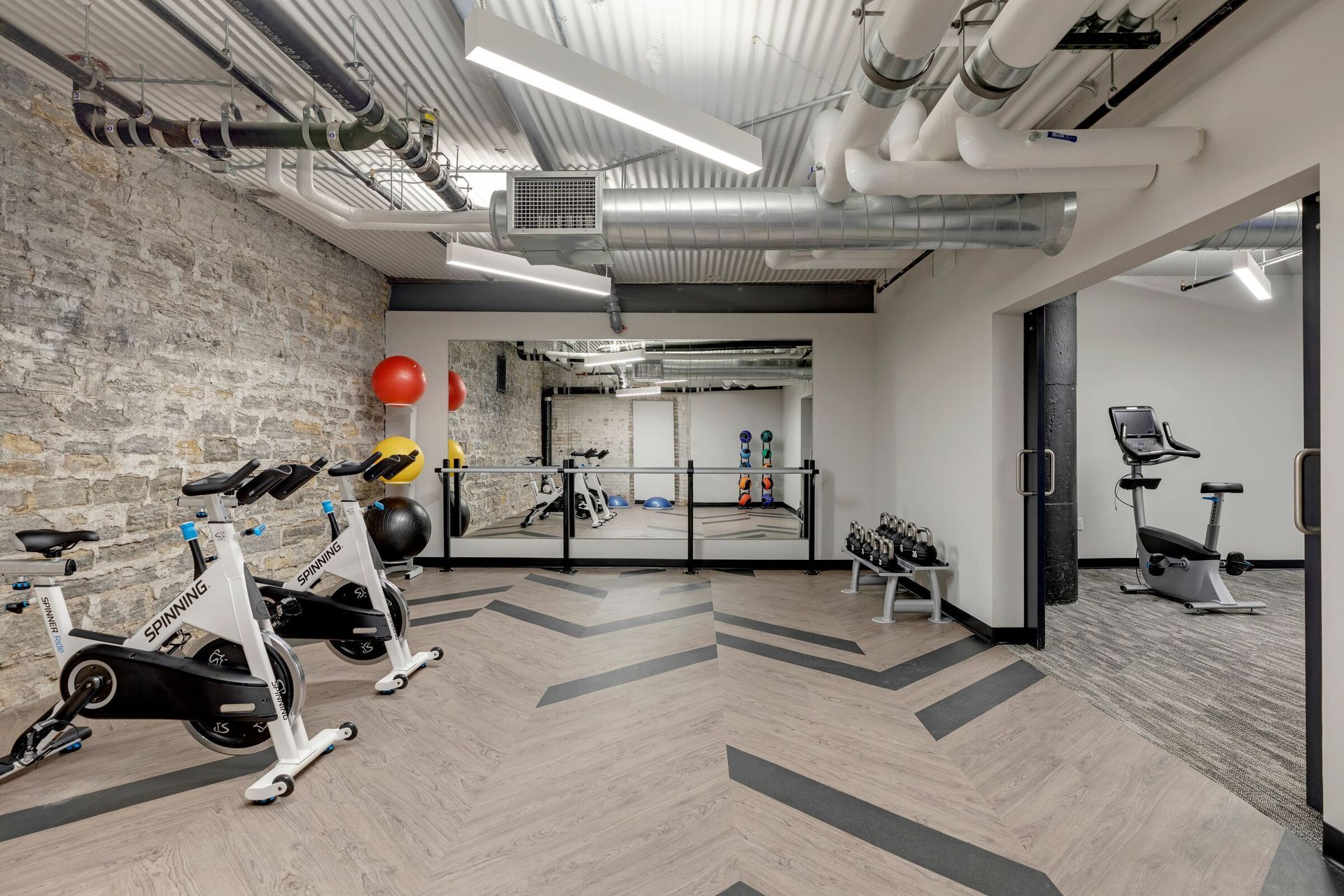 Indoor building gym with spin bikes, free weights, and a mirrored wall at The Jax in St. Paul, MN.