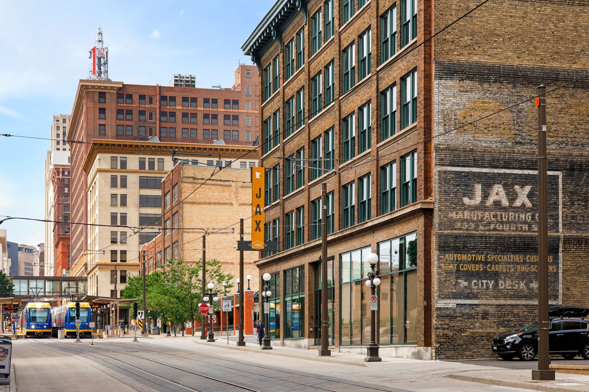 Street scene with brick buildings, trolley, and a faded 
