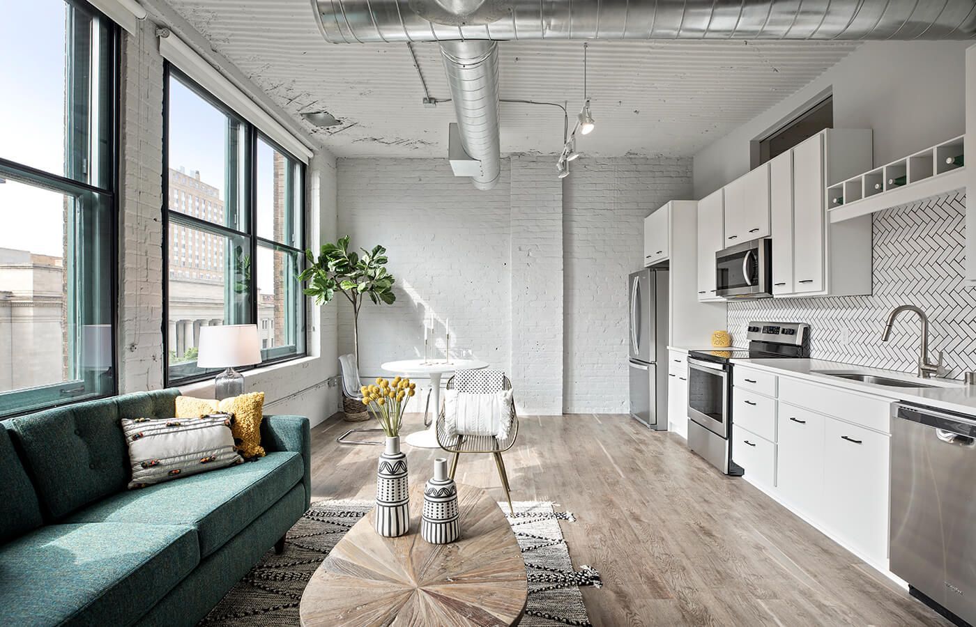 Open-concept living area and kitchen in a modern apartment with large windows at The Jax in St. Paul, MN.