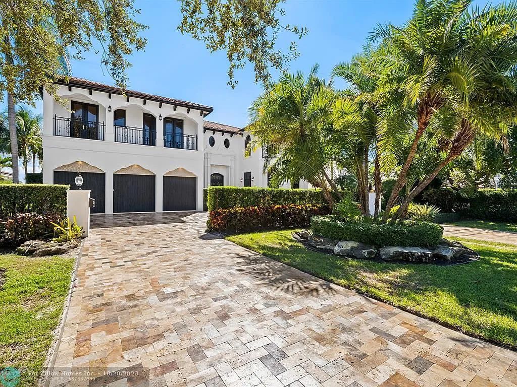 A large white house with a brick driveway leading to it.