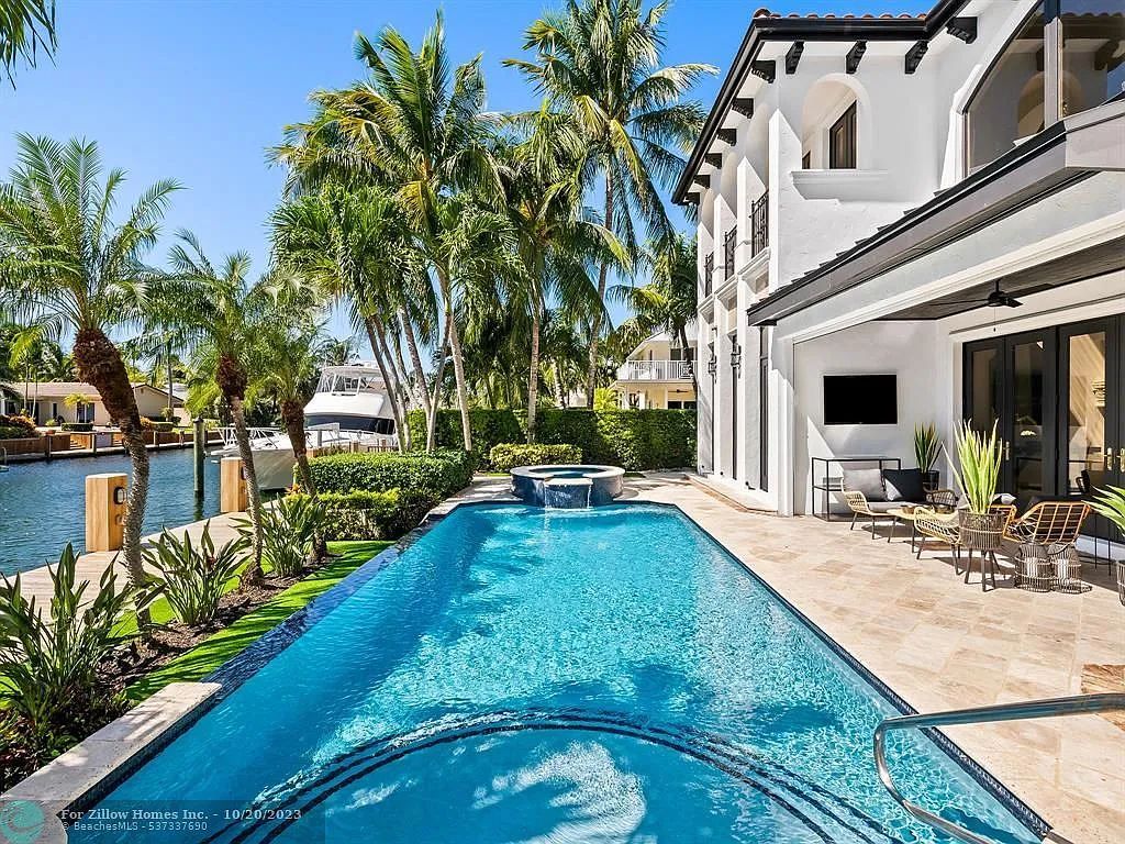 There is a large swimming pool in the backyard of a house.