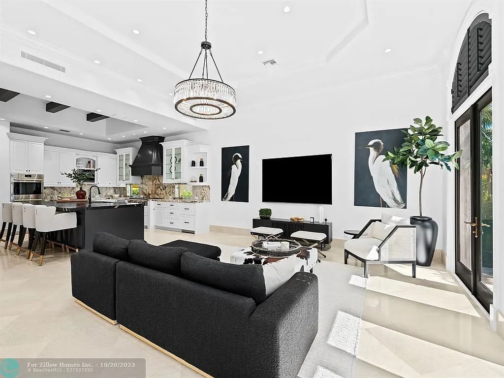 A living room with a black couch and a flat screen tv.