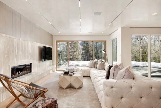 A living room with a couch , chair , coffee table and fireplace.